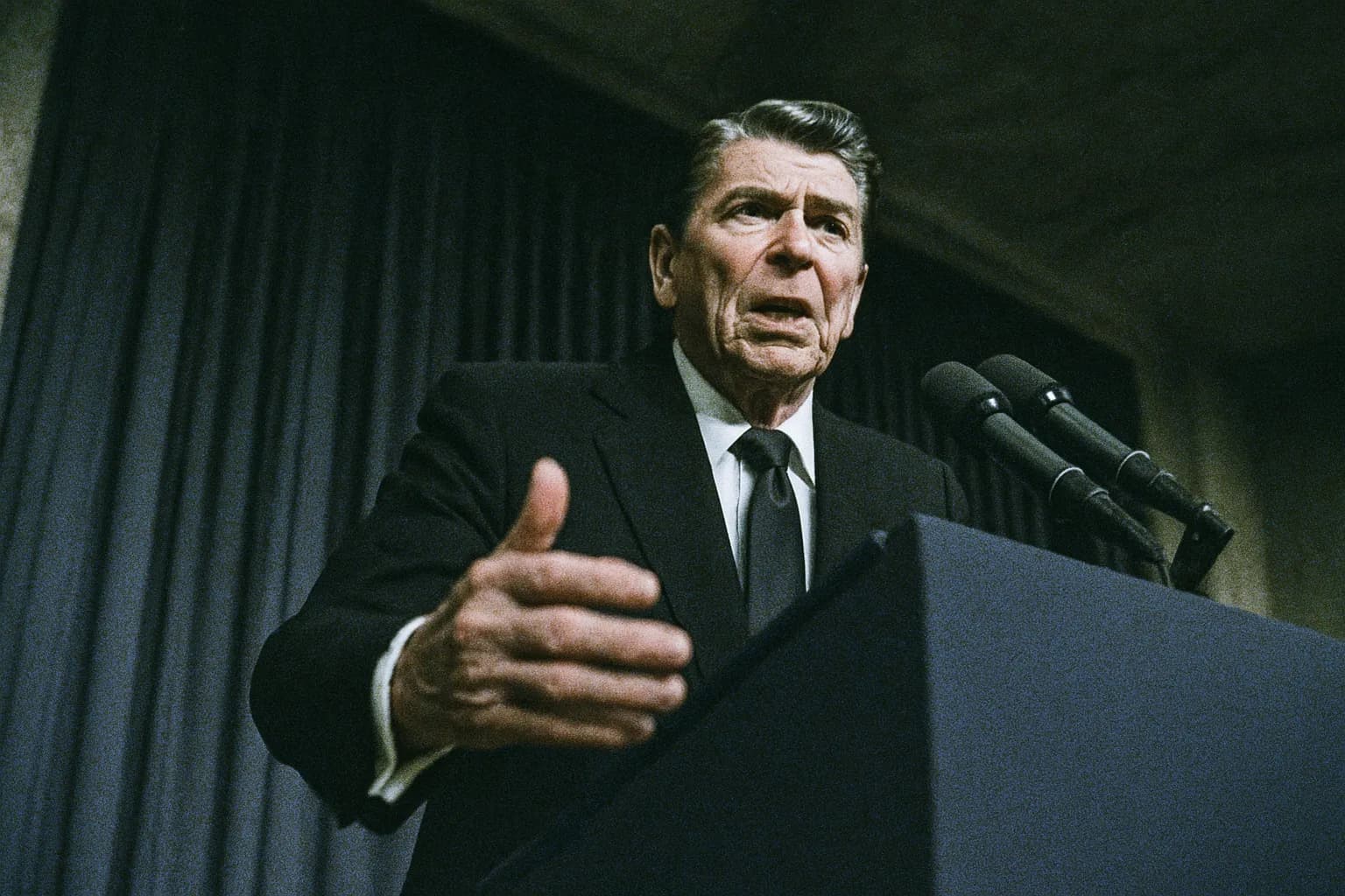 En figur, der ligner Ronald Reagan, står bag et podium midt i en tale, omgivet af en atmosfære af spænding og alvor, der formidler tyngden af Iran-Contra-affæren.